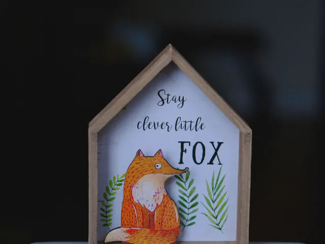 Drewniany obrazek w kształcie domku z lisem i napisem Stay clever little fox