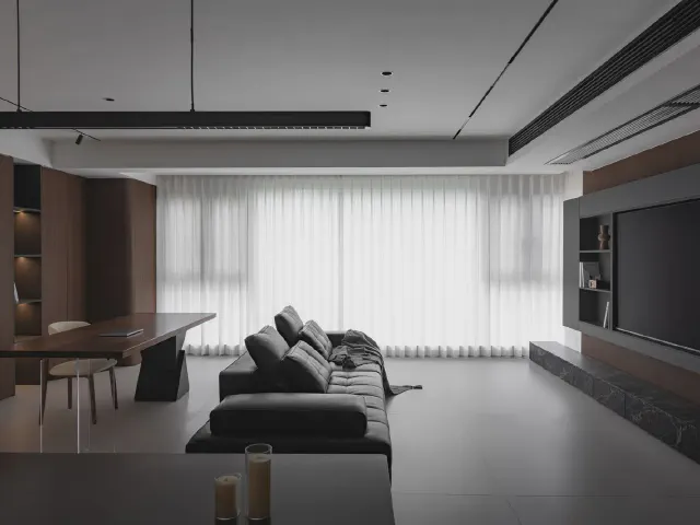Ciemny minimalistyczny salon z czarną sofą, zabudową z drewna i zwiewnymi firanami